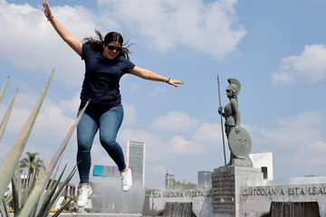 Mujer feliz brincando a lado de la Minerva de la ciudad de Guadalajara 