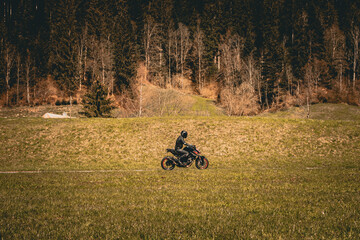 Motorradfahrer vor einem Wald