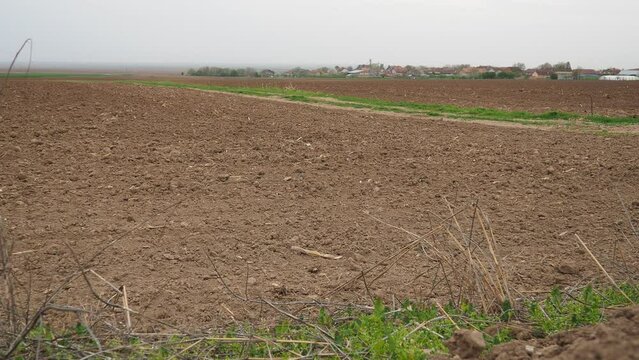 A tractor-plowed field in Chalma, Serbia. Agribusiness. Agricultural land. Fertile black soil. Row of furrows in a plowed field prepared for planting crops in the spring. Horizontal perspective view.