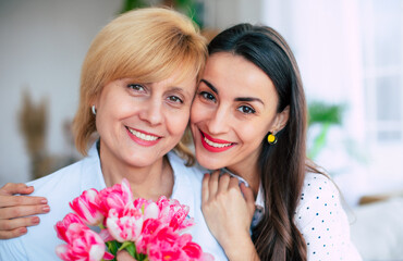 Loving young adult female daughter congratulate her mature mother with birthday anniversary at home. Birthday, Mothers day, women's day, retired, family, relation, motherhood. - 773486101
