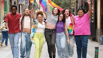 Diverse group of young people celebrating gay pride festival day - Lgbt community concept with guys and girls hugging together outdoors - Multiracial trendy friends standing on streets - Powered by Adobe
