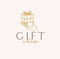 Hand holding gift box with lettering gift shop drawing in linear style on beige background