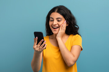 Naklejka premium Excited lady with smartphone on teal