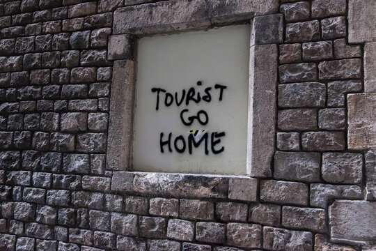 Tourist go home Schriftzug auf einer Wand in Barcelona, Spanien