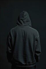 A man in a black hoodie standing with his back to the camera. Perfect for mystery or suspense-themed projects