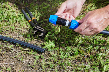 Assembling irrigation water supply, plumber connects pipes with compression coupling fitting.