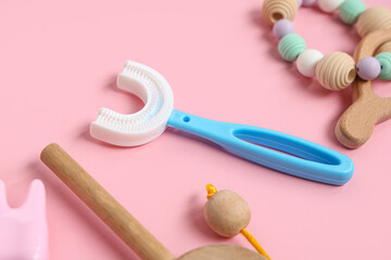 Children's toothbrush with toys on pink background, closeup