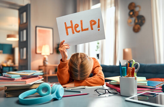 Asking for assistance. Unrecognizable kid laying on table and raising paper with hand drawn lettering help