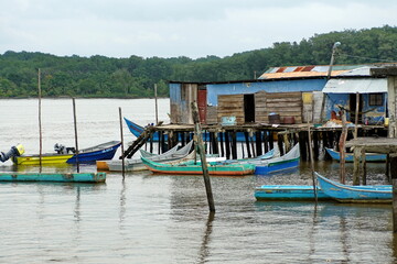 Fototapeta na wymiar Boats moored in front of wooden shacks in Limones, Esmereldas, Ecuador