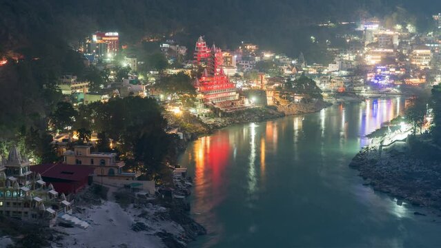 Dusk to night timelapse showing Hindu temples on the banks of the sacred Ganges river in Rishikesh, Uttarakhand, India, zoom in. 
