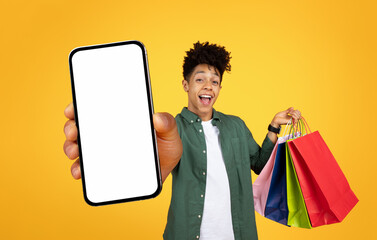 African american guy presenting smartphone with blank screen