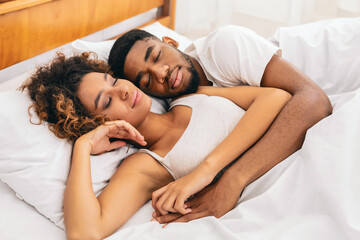 Couple in a tender embrace on white sheets