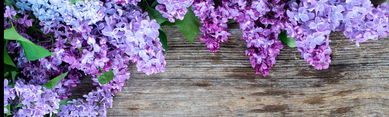 Fresh lilac flowers over wooden background with copy space, flat lay floral composition with copy space