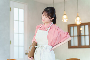 腰痛の女性飲食店スタッフ