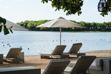 Beach beds with umbrellas, on the ocean coastline, on the hotel grounds among greenery.