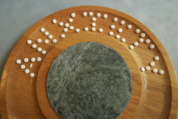 Anxiety medication on a wood cheese platter arranged to spell 'ANXIETY' along the curvature of the board.