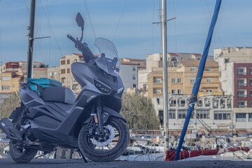 Motorcycle in a port with city buildings in the background
