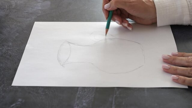 Artist woman creates art sketch on paper using pencil She demonstrates process showing talent and creativity in art. Witness mastery of art form as she brings vision to life through detailed sketching