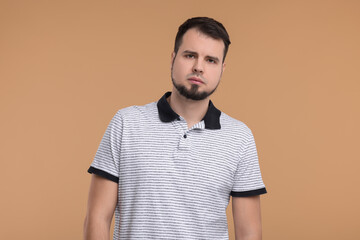 Portrait of sad man on beige background