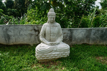 Buddha statue on the grass for sale at the side of the road. Ubud, Bali, Indonesia.