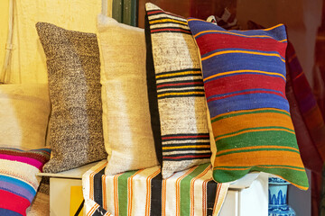Decorative colorful soft textile pillows on a shelf interior - 773578109