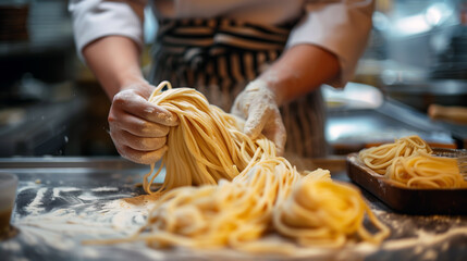 A detailed close-up captures the hands of a chef dusted with flour as they skillfully shape fresh, golden pasta dough into thick noodles. - obrazy, fototapety, plakaty