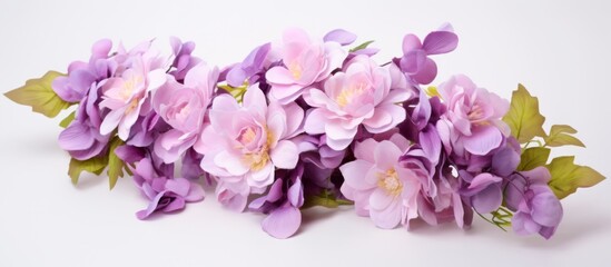 Purple flowers are neatly arranged on a clean white surface, accompanied by vibrant green leaves for a refreshing display