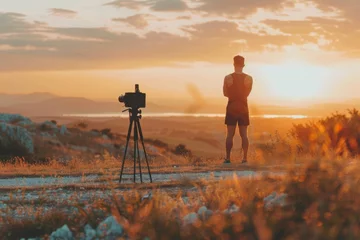 Foto auf Acrylglas A fitness content creator filming an outdoor workout session at sunrise, with workout equipment and a beautiful landscape in the background. © Ammit
