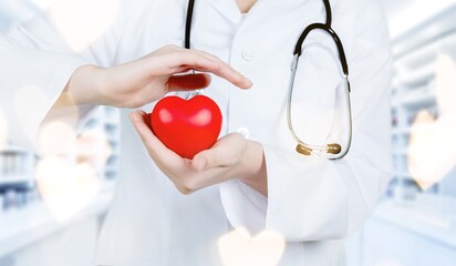Hands of cardiologist doctor hold red heart