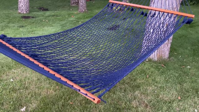 Blue woven hammock swings easily between two trees
