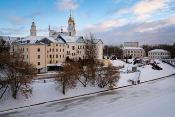 Fototapeta na wymiar View of the Vitba River embankment, the Town Hall and the Church of the Resurrection of Christ on a winter day, Vitebsk, Belarus