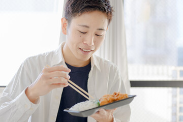 唐揚弁当を食う男子