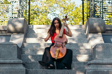 A young woman playing the cello outdoors © PEDROMERINO