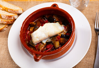 In deep clay pot, casserole of juicy vegetables, complemented by tender cod fillet with xanfaina...