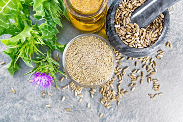 Flour milk thistle in bowl on stone table top