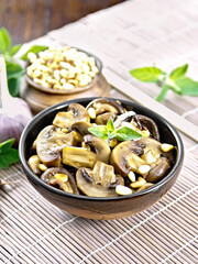 Champignons with oregano and nuts in bowl on brown napkin