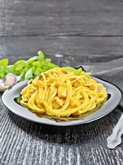 Spaghetti with pumpkin and bacon in plate on wooden table