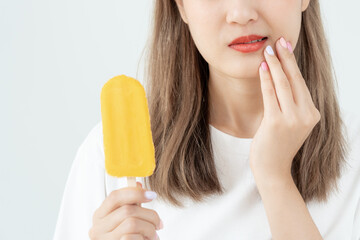 Asian woman feel sensitive teeth after eating ice cream, female suffer tooth, decay problems,...