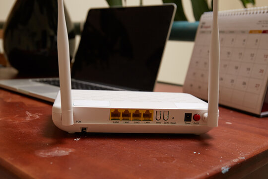 Photo of Wifi Router and laptop on the wooden table 