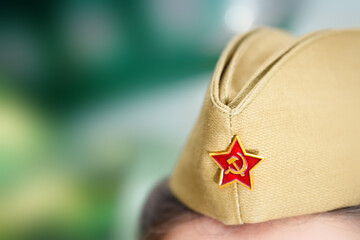 A soldier's cap with the emblem of a red star, hammer and sickle, worn in honor of the Great Victory Day on May 9, close up.