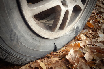 Close-up of a car wheel with a torn tire on the side.
