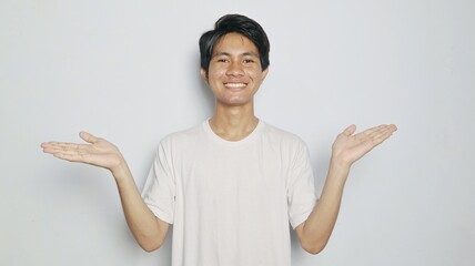 Excited young Asian man in white shirt showing open palms