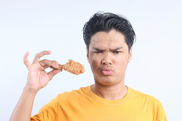 Asian man holding fried chicken with pout lips