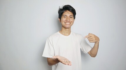 young excited asian man in white shirt pointing open palm