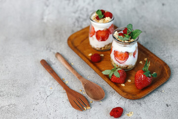 Healthy beverages of strawberry parfaits on wooden tray