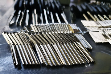 There are numerous key blanks laid out on the table of a locksmith who specializes in custom key duplication services.
