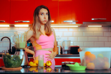 Sporty Girl Trying a De-bloating Diet for a Flatter Stomach. Unhappy woman suffering from a belly...