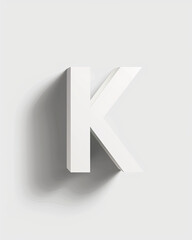 A white, isometric "K" casts a deep shadow on a gradient light grey background.