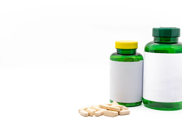 Medicine bottles with blank labels ready to edit or write on them, next to pills, isolated on white background, with copy space. pharmacy and medicine concept