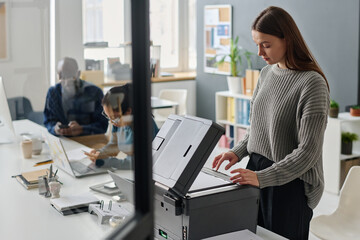 Woman Making Copy Of Document At Work - 773675100